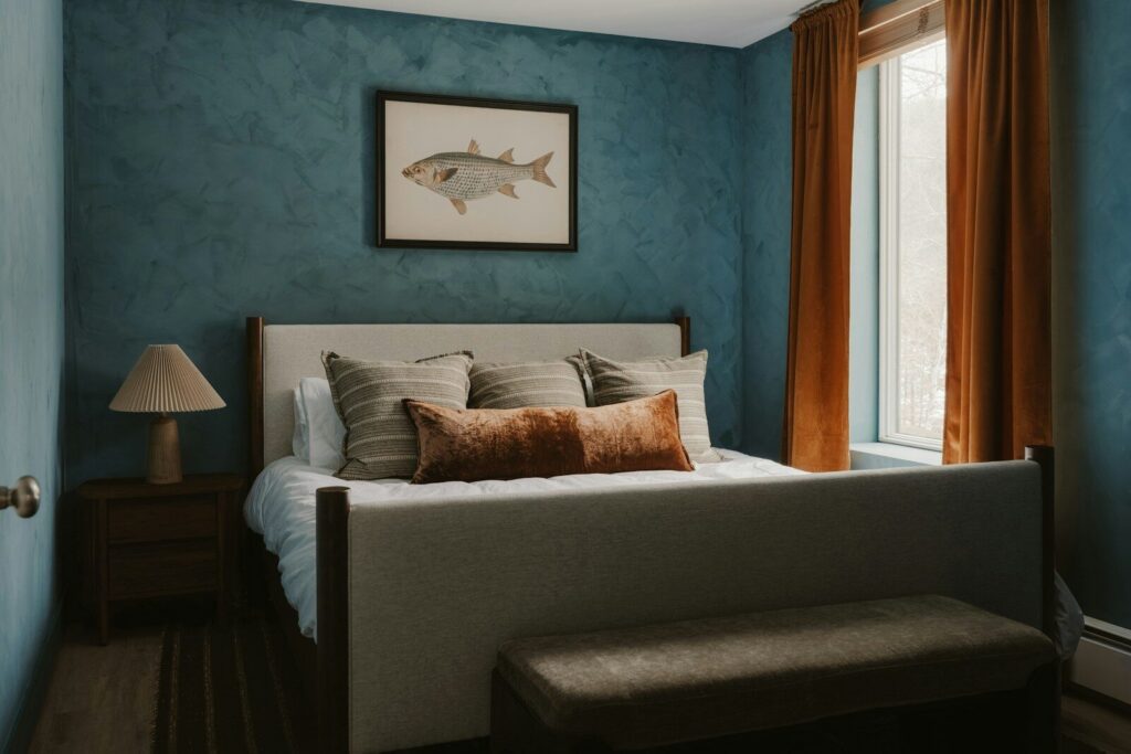 Bedroom with blue textured walls and a queen-sized bed.