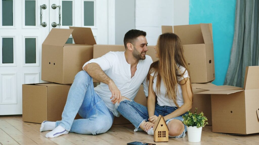 Couple surrounded by moving boxes in new home